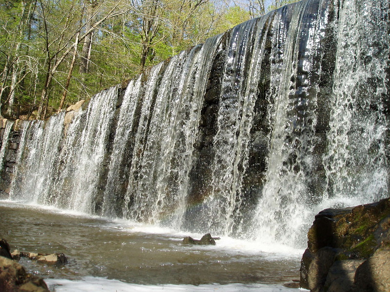 Water spilling over a stone dam